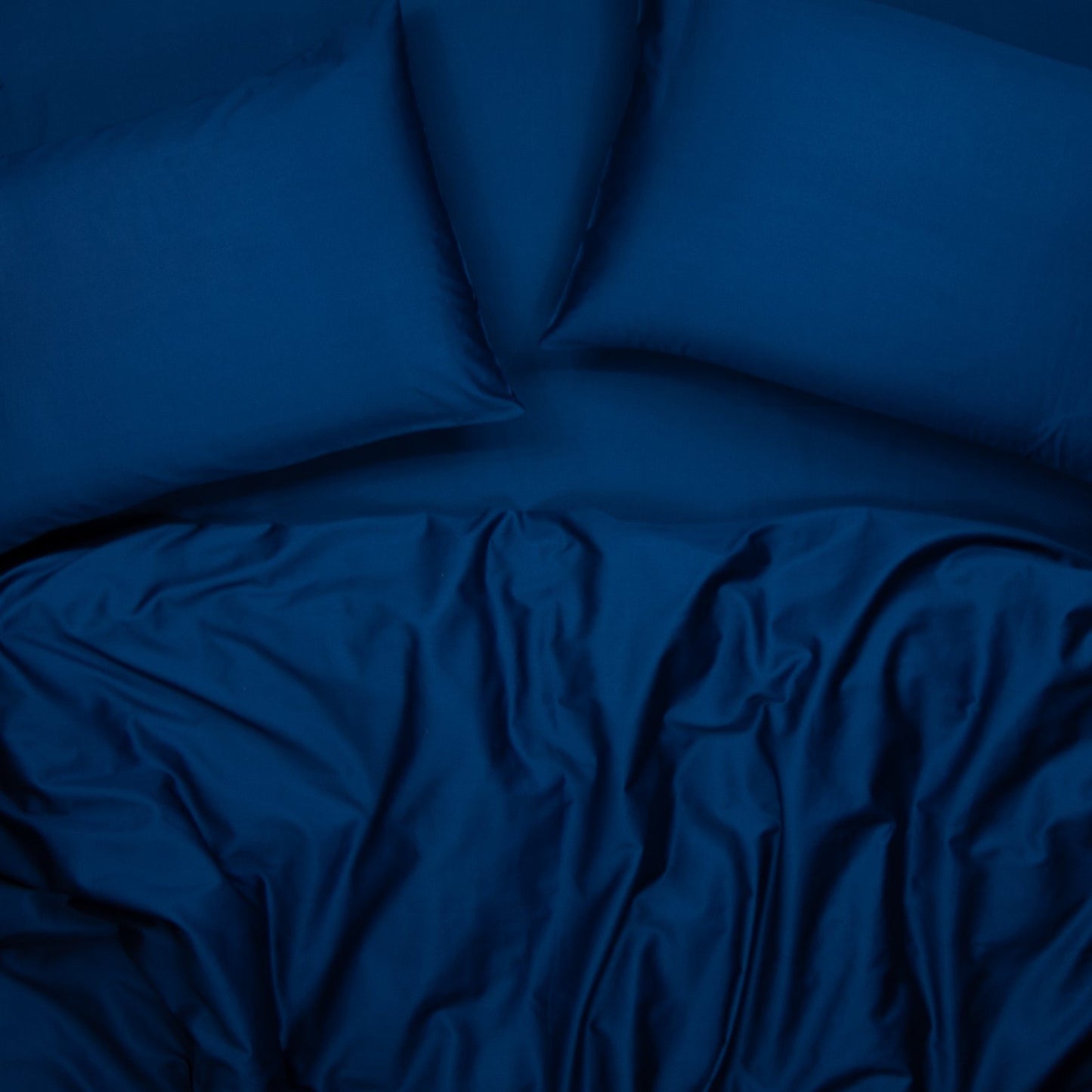 Birds eye view of organic cotton quilt cover set with pillowcases and quilt cover in classic blue