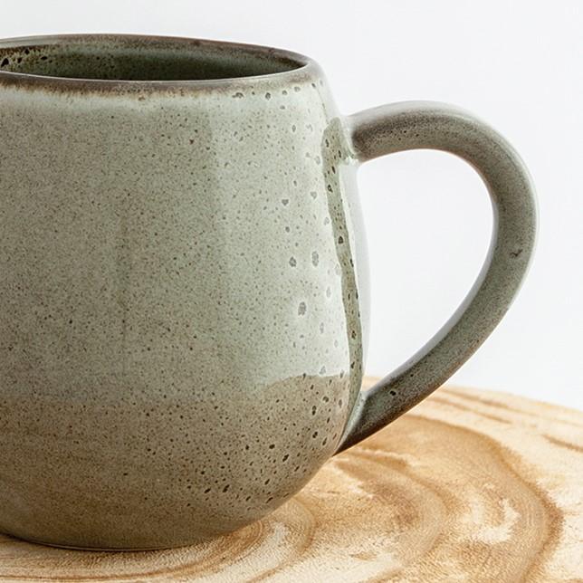 Close up of a Robert Gordon banksia grey canvas mug coffee cup sitting on a natural wooden round side table