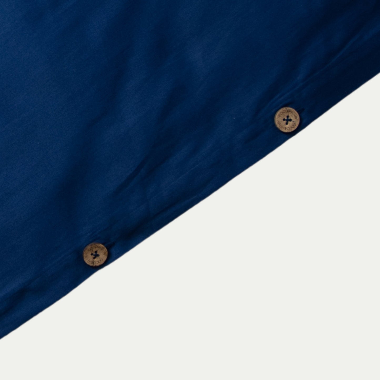 Close up of quilt cover edge with coconut buttons in classic blue