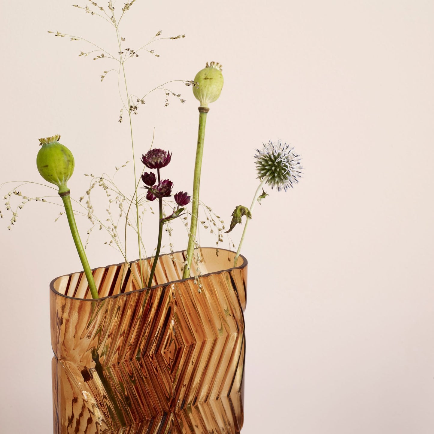 Hubsch Interior Nordic designer diamond textured vase in amber glass inside on white background with a few flowers in it