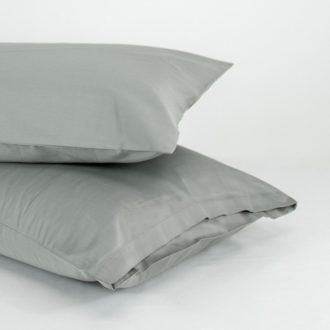 Stacked organic cotton pillowcases in sleet grey